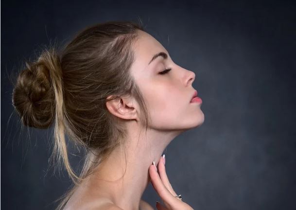 woman side profile with hand on neck, showcasing a skin tightened jawline